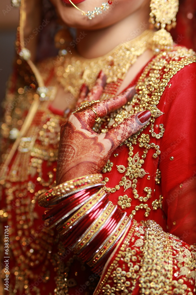 Bride Showing hands applied henna , decorative hands, bangles red dress mehndi, rings and jewelry , indian pakistani bride
