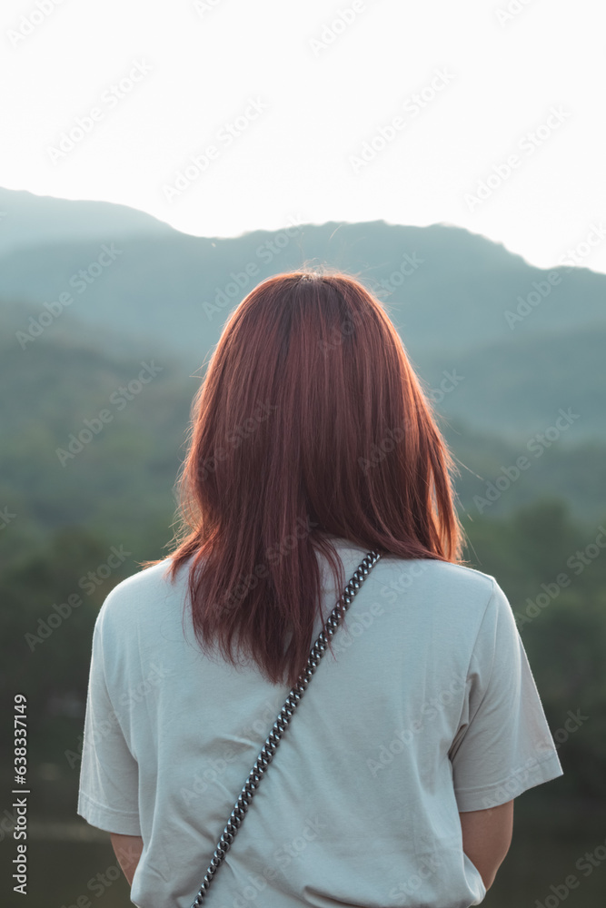 Back scene of woman alone with feeling lonely and depressed on blurred background of beautiful nature scenery . concept of woman who had to be alone in past was depressed when she encountered problems