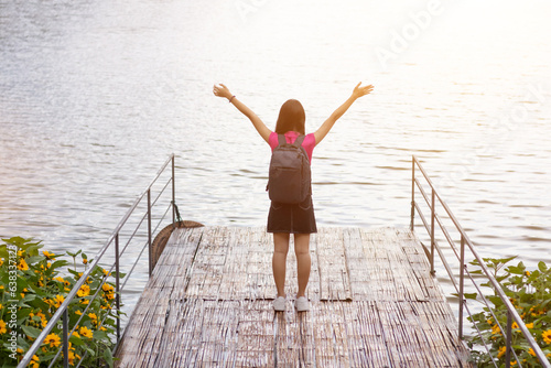 фотографія silhouette of young woman standing on top of mountain peak with his hands raised above his head as symbol of worship and invocation of God blessings with belief and power of faith in God