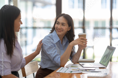 Two happy asian businesswoman talking and consulting working together in the office