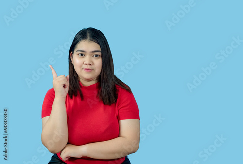 Portrait girl young woman asian chubby fat cute beautiful pretty one person wearing a red shirt is sitting, looking smiling happily holding copyspace imaginary on the blue background