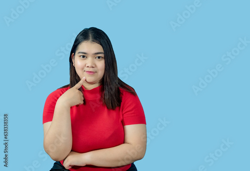 Portrait girl young woman asian chubby fat cute beautiful pretty one person wearing a red shirt is sitting smiling enjoy happily looking wow to copyspace imaginary on the blue background