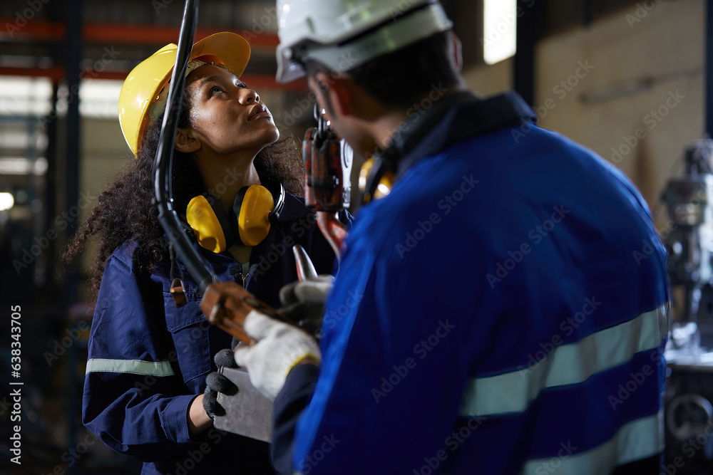factory workers or engineer operating remote switch to control machine and looking above in the factory factory workers or engineer operating remote switch to control machine and looking above in the factory