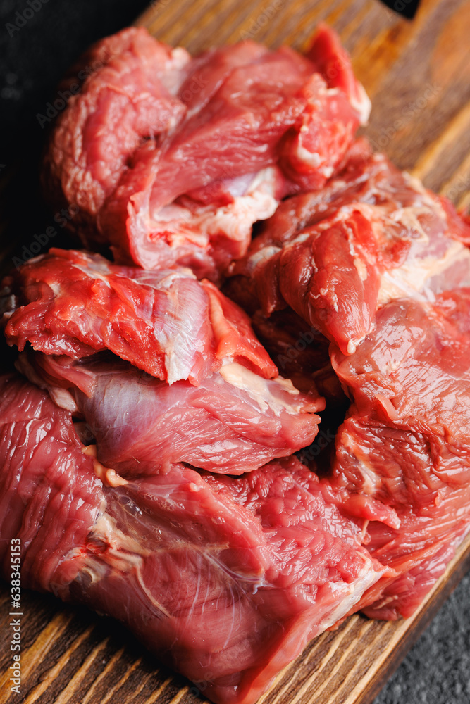 Closeup raw lean beef meat on wooden board, dark background