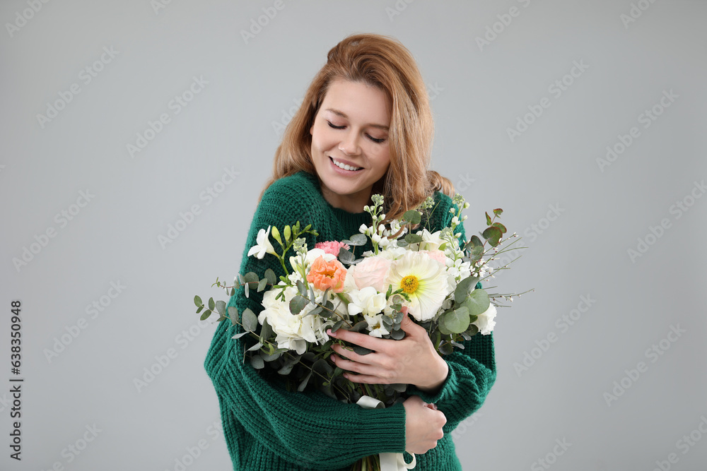 Beautiful woman with bouquet of flowers on grey background Beautiful woman with bouquet of flowers on grey background
