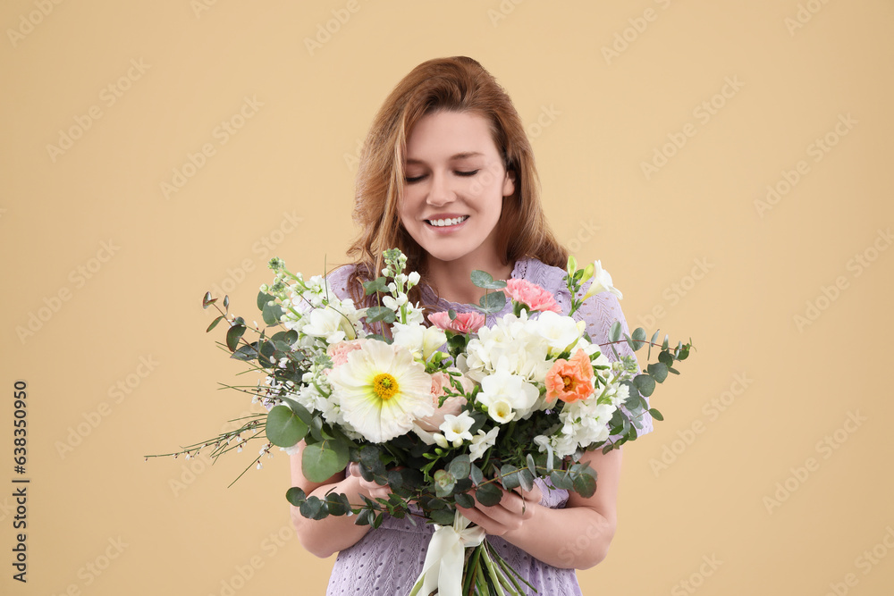 Beautiful woman with bouquet of flowers on beige background