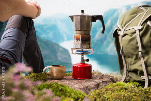 Картината върху платно Cooking, making coffee or tea on a portable camping gas burner with a red gas cylinder with a Scandinavian nature background