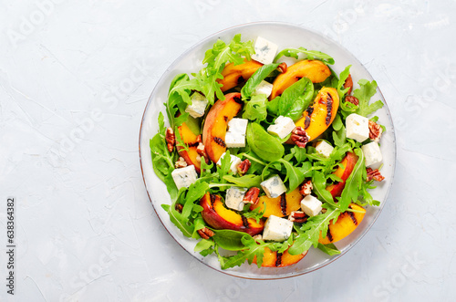 Grilled Peach Salad with Blue Cheese, Pecans and Arugula on Bright Light Blue Background