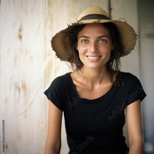 jeune femme brune de 30-35 ans en t-shirt noir et chapeau de paille