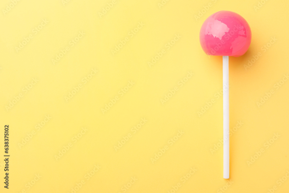 One tasty lollipop on yellow background, top view. Space for text One tasty lollipop on yellow background, top view. Space for text