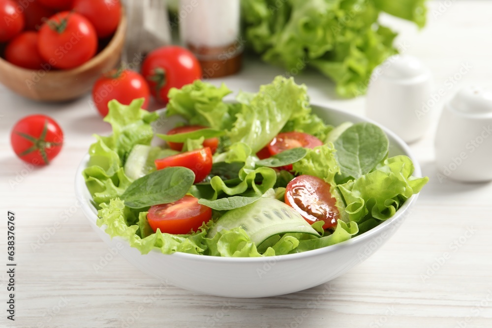 Delicious vegetable salad on white wooden table, closeup