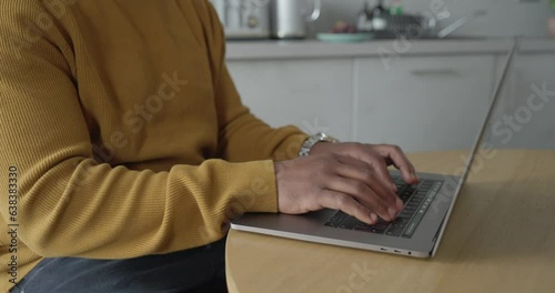 Man using laptop while working in kitchen