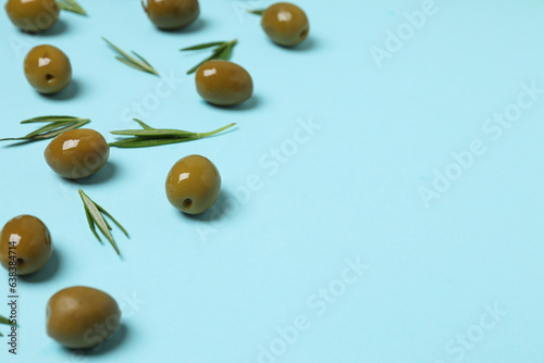 Olives and tree leaves on blue background, space for text