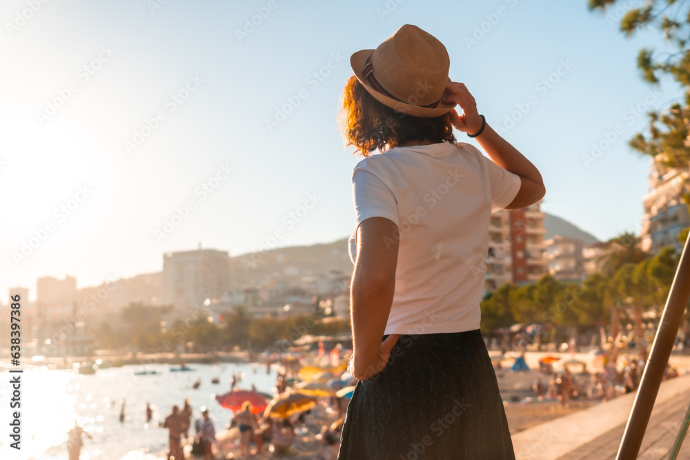 Portrait of a tourist woman in the sunset of Sarande or Saranda in the Albanian riviera walking along the boulevard, Albania