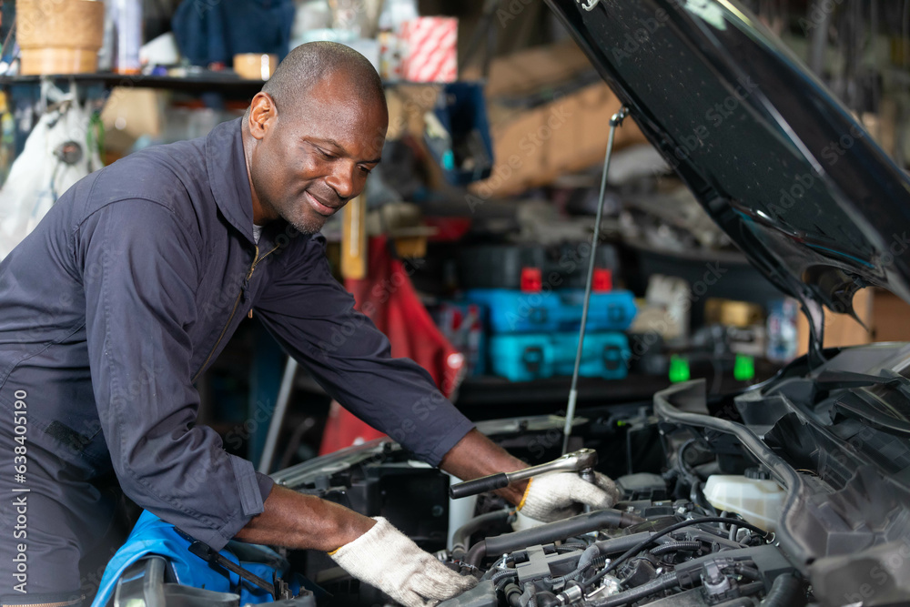 African mechanic worker checking and fixing a car in garage African mechanic worker checking and fixing a car in garage