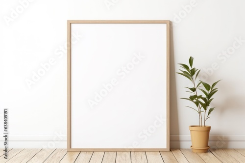 white wall with blank wooden frame and green plant mock up on wooden floor © id512