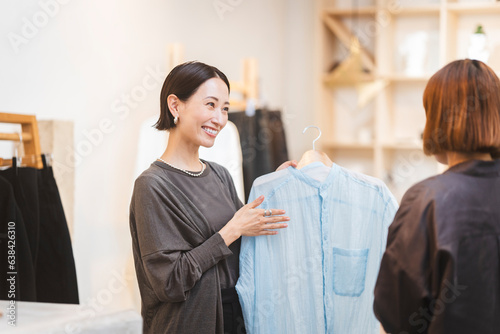 Obraz na płótnie 働く日本人女性/アパレル店員が接客をしている