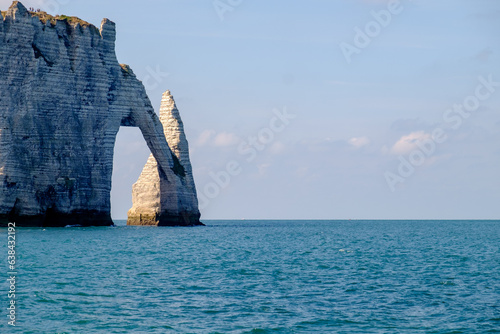 Calm coast with rocky cliff, blue ocean, and serene horizon over water. at etrata, france photo