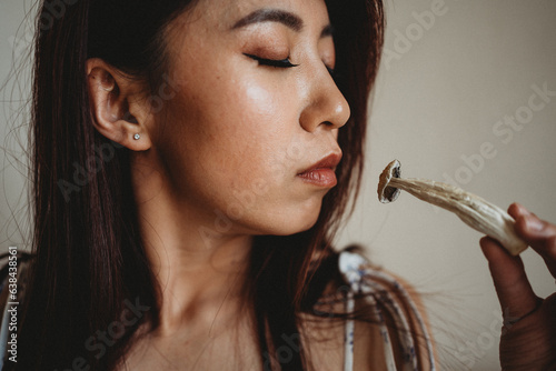 Woman holding psychedelic mushroom near face