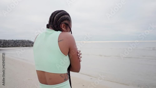 woman felling cold on the beach cloudy morning in winter woman shiver with cold photo