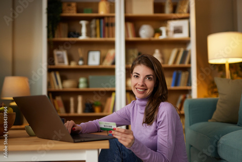 Young woman online shopping using the laptop at home