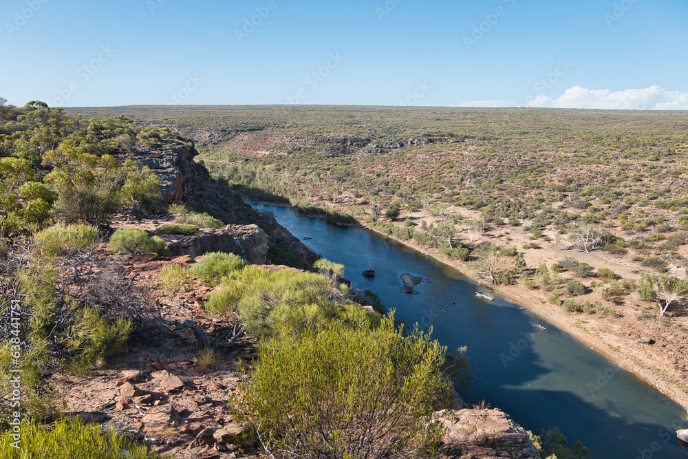 Obraz premium Looking into a gorge and to a river from Hawk's Head Lookout in Kalbarri National Park, Western Australia. Stunning views of the Kalbarri Gorges and Murchison River. Western Australian landscapes.
