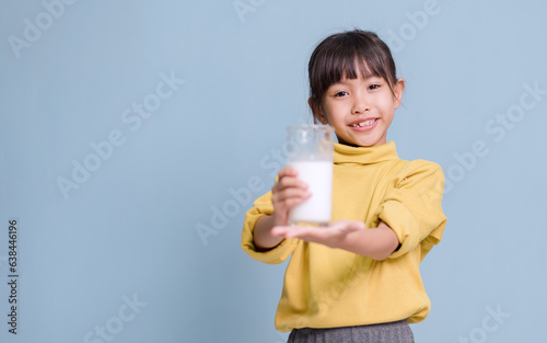 A little girl is drinking milk and very happy.
