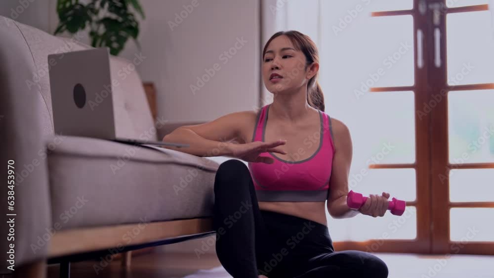 Young Asian woman blogger in sportswear recording video for teaching on laptop on mat in home, Training workout concept. Young Asian woman blogger in sportswear recording video for teaching on laptop on mat in home, Training workout concept.
