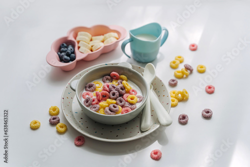 Dry children's breakfast. Cute children's plates and bowl with colorful cereal rings of milk. Creative serving for baby. Concept of kids menu, nutrition and feeding.