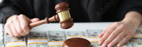 Фотография Judge with wooden gavel and a lot of dollar bills close-up.