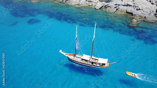 Boat, sailing in blue water and summer sun on ocean holiday, relax in freedom and nature. Yacht vacation, aerial of travel and tropical cruise on adventure to Greek island with sunshine, fun and sea.
