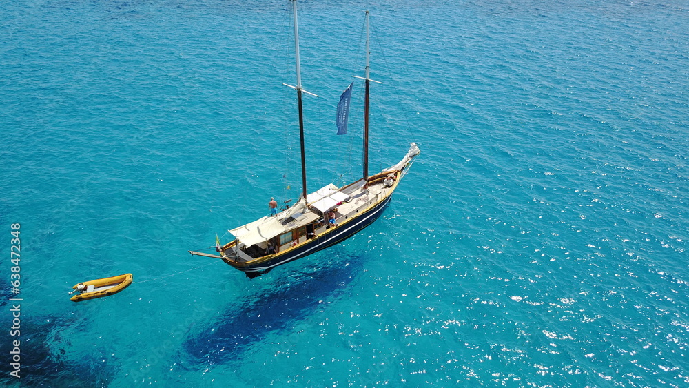 Fototapeta premium Yacht, sailing in Croatia and sun on ocean holiday, relax in freedom and nature with clean blue water from above. Boat vacation, travel in summer and tropical cruise on sea adventure with island fun.