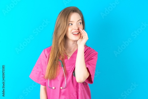 beautiful doctor woman standing over blue studio background  hear incredible private news impressed scream share photo