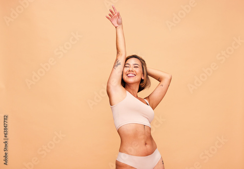 Dance, self love and happy woman in lingerie in studio with skincare, results and body positivity on wall background. Beauty, cosmetics and female model dancing for wellness, good mood or freedom