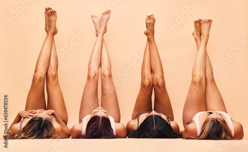 Diversity, skincare and legs of women in studio for beauty, comparison or wellness on wall background. Difference, beauty and female friends relax in a line with feet up for glowing skin or treatment