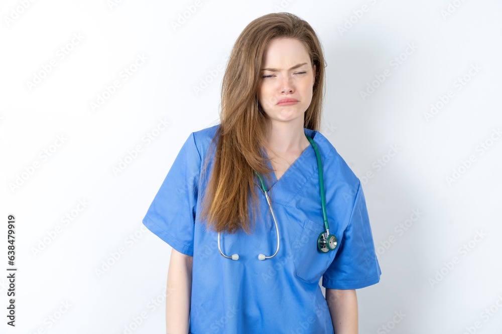 Dismal gloomy rejected young beautiful doctor woman has problems and difficulties, curves lower lip and closes eyes in despair, being in depression Dismal gloomy rejected young beautiful doctor woman has problems and difficulties, curves lower lip and closes eyes in despair, being in depression