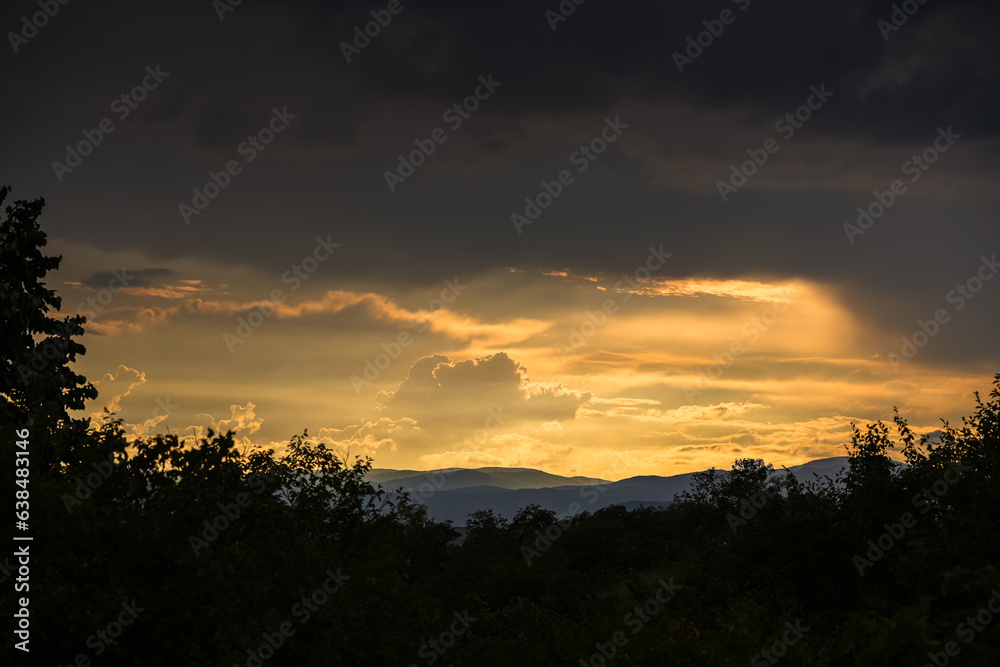 Amazing nature sky landscape photo with dark clouds layer over a clear sunset sky. Cloud study meteorological photo.