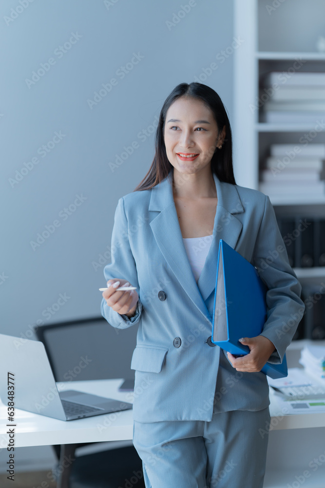 Shot of a beautiful young financial assistant sitting in front of laptop and fill the form in the office. Shot of a beautiful young financial assistant sitting in front of laptop and fill the form in the office.