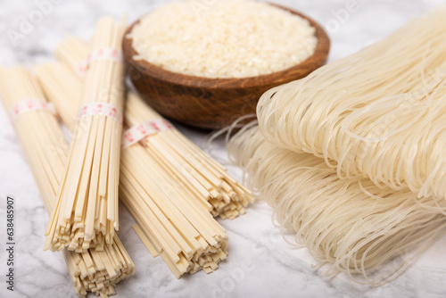 Funchoza.Dried raw rice noodles and rice on a textured background.Noodles with rice flour. Diet food. Healthy food. Place for text. Place for copying.