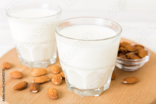 Top view of the almond milk in the glass bottle with almond nuts on the colored table. top view vith copy space