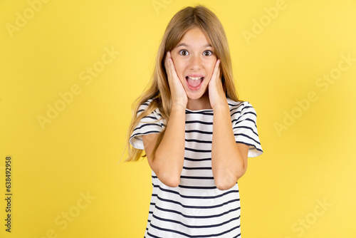 Beautiful caucasian kid girl wearing striped T-shirt Pleasant looking cheerful, Happy reaction