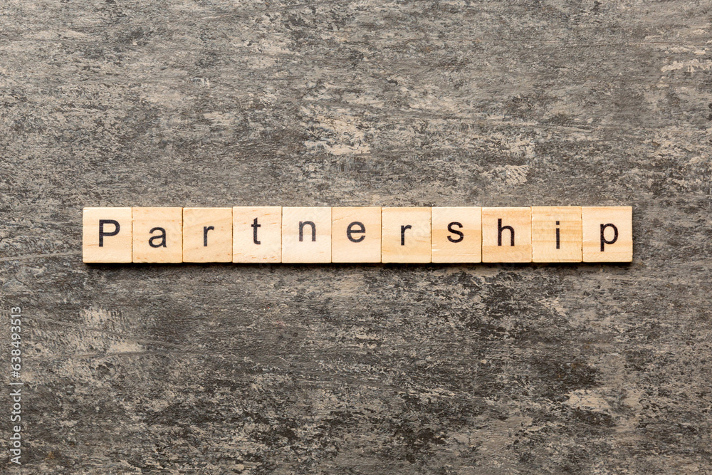 partnership word written on wood block. partnership text on cement table for your desing, concept partnership word written on wood block. partnership text on cement table for your desing, concept