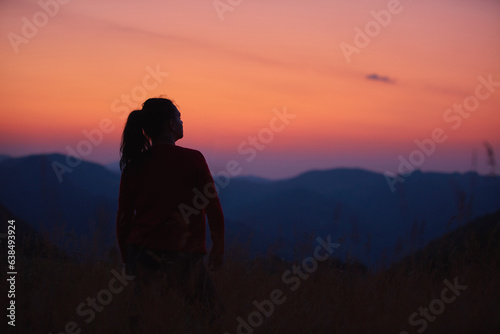 Silhouette of a woman enjoying peacefully in nature.