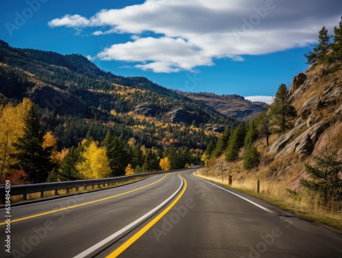 A picturesque mountain drive, surrounded by fall foliage in vibrant shades; the distant horizon gently blurring into autumnal hues.