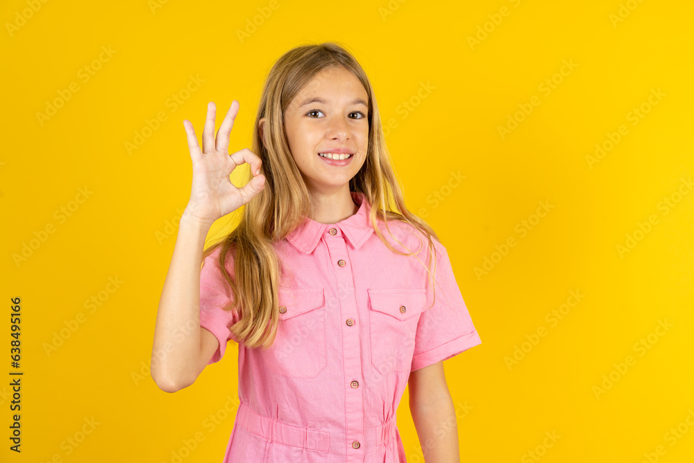 Beautiful caucasian kid girl wearing pink shirt hold hand arm okey symbol toothy approve advising novelty news Beautiful caucasian kid girl wearing pink shirt hold hand arm okey symbol toothy approve advising novelty news