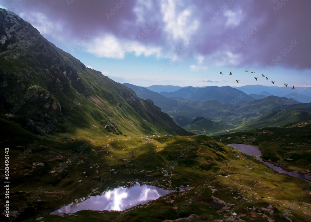 Fototapeta premium Mountain range with clouds in the sky and reflective water