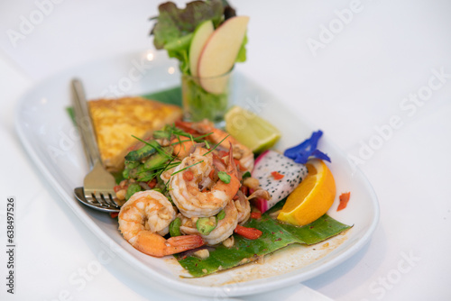 seafood and fruit spicy salad on a white plate