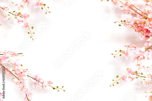 Flat lay of Pink flowers with yellow pollen and lace on a white background.