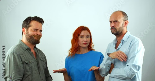 A group of coworkers, a woman and two men, looking at the camera. They are clearly disapproving of something, as they are all shaking their heads and making hand gestures that mean 