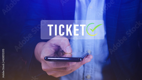 Businessman holding smartphone with button Ticket word, Business, Technology, internet and networking concept businessman pressing online booking button on virtual screens.